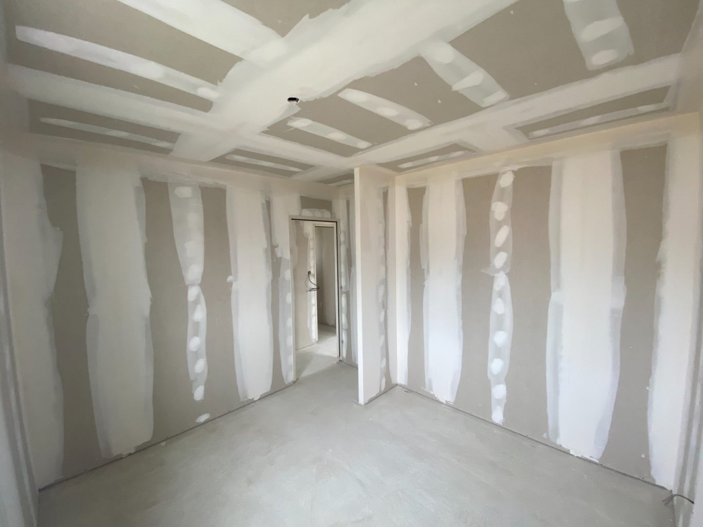 Intérieur d'une pièce en construction avec murs en plaques de plâtre non finis.