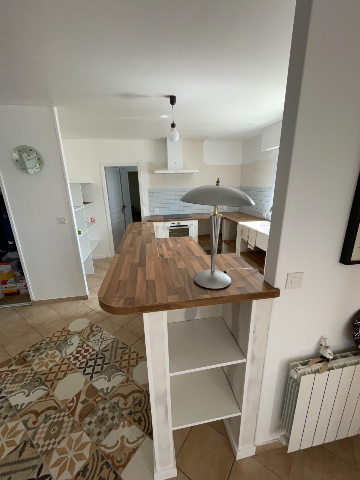 Plan de travail en bois avec lampe, espace de cuisine lumineux et moderne.